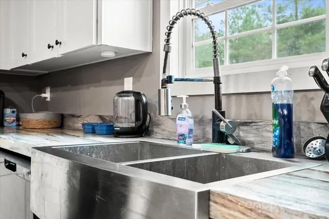 a kitchen with stainless steel appliances granite countertop a sink a stove and a wooden cabinets