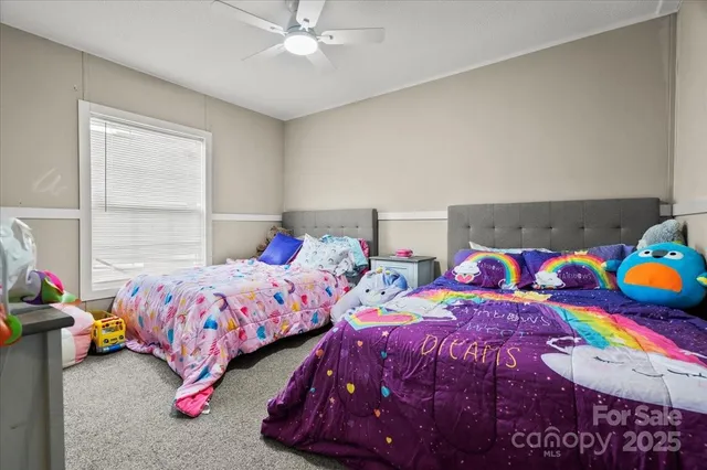 a bedroom with two bed and a window