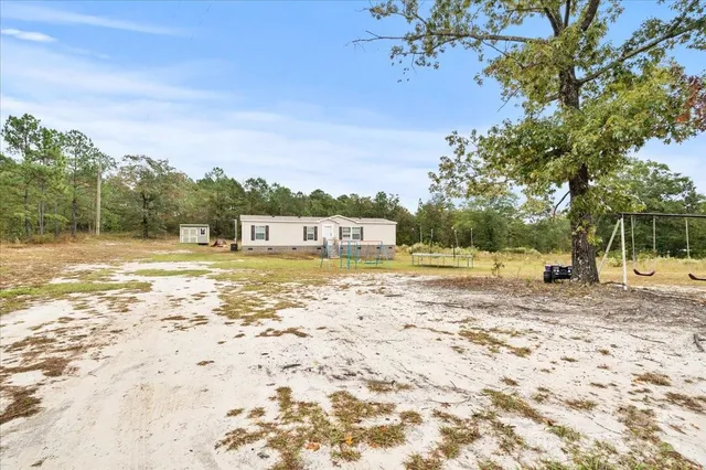 a view of yard with swimming pool and trees