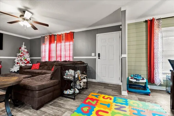 a living room with furniture and a baby crib