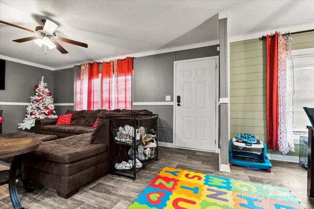 a living room with furniture and a baby crib