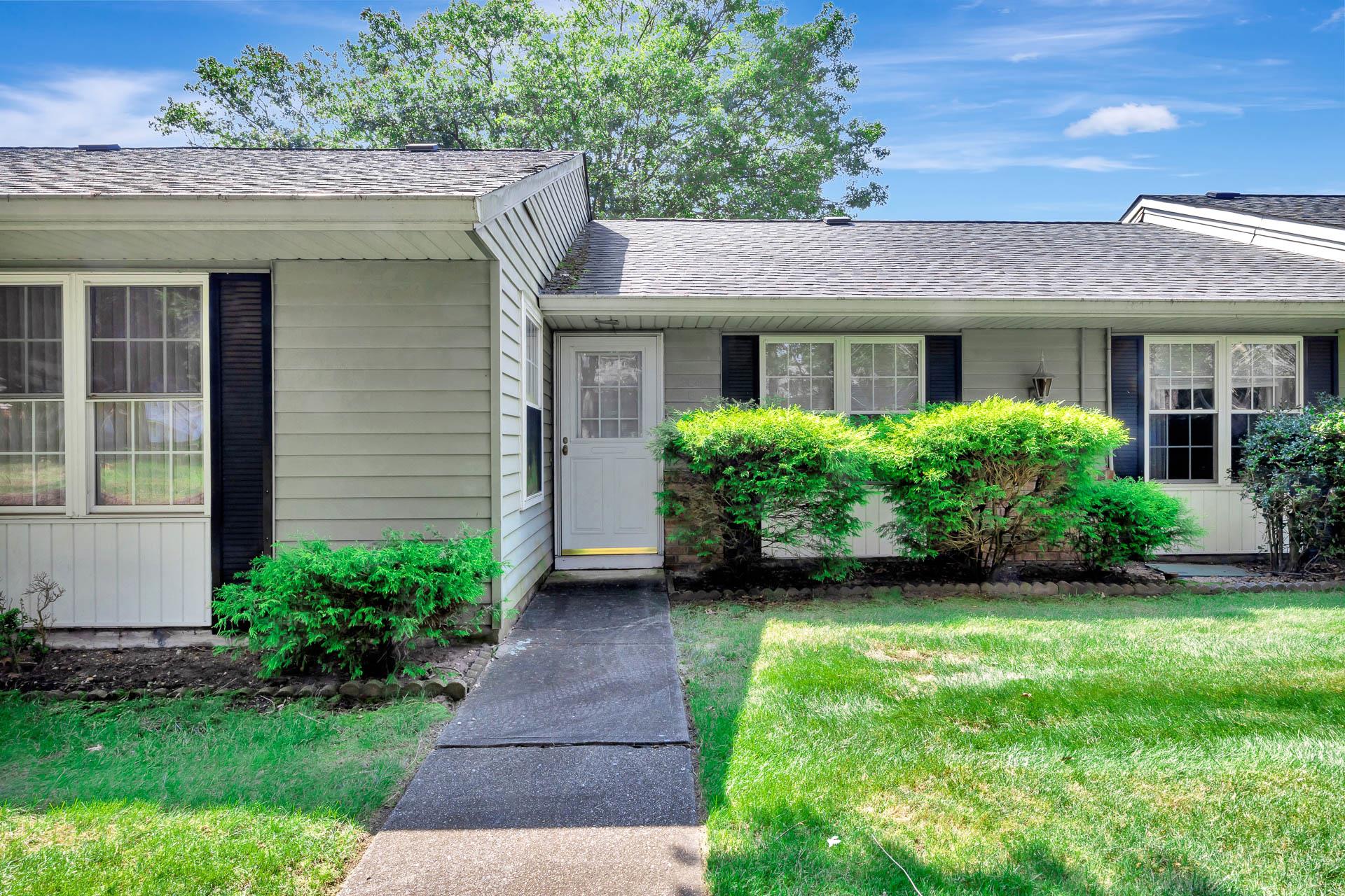 a view of a house with brick walls and a yard with plants