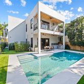 a view of a patio with couches table and chairs with plants and wooden fence