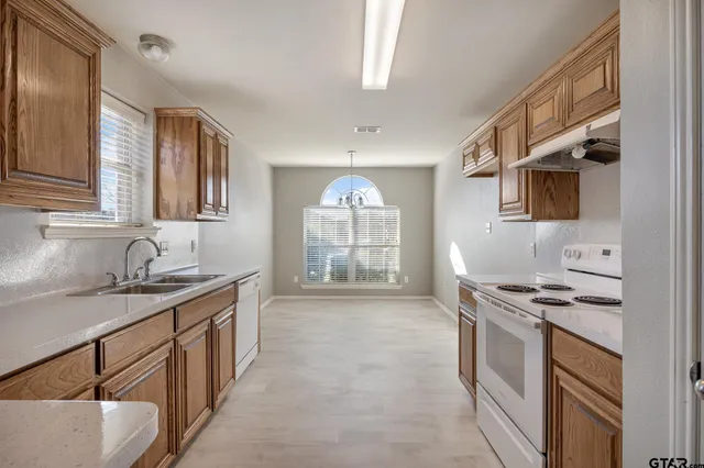 a kitchen with stainless steel appliances granite countertop a sink stove and cabinets