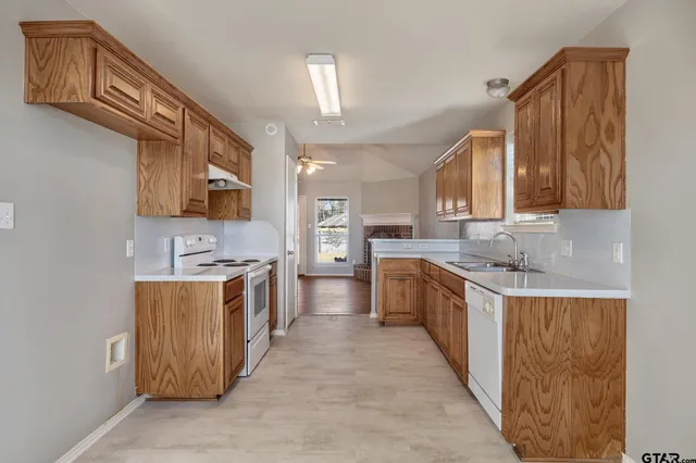 a large kitchen with stainless steel appliances granite countertop a stove a sink dishwasher and a refrigerator