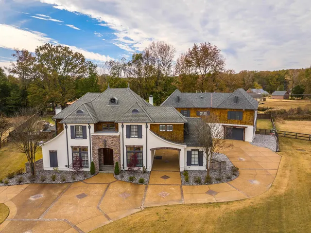 a view of a big house with wooden fence