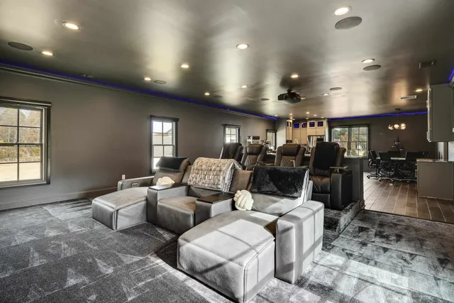 a room with furniture pool table gym equipment and windows