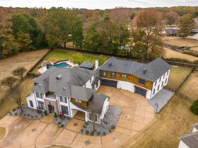 an aerial view of a house with a yard swimming pool and mountain view