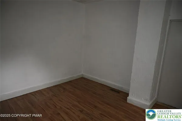 a view of an empty room with wooden floor