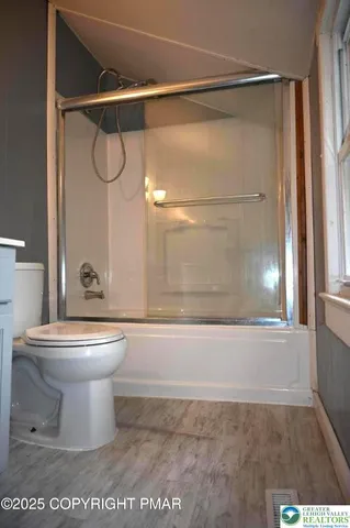 a bathroom with a toilet and a shower