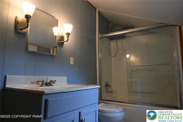 a bathroom with a sink vanity granite toilet and a shower