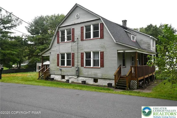 a front view of house with yard and green space