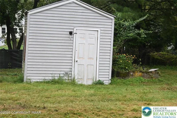 a view of a white house with a yard and plants