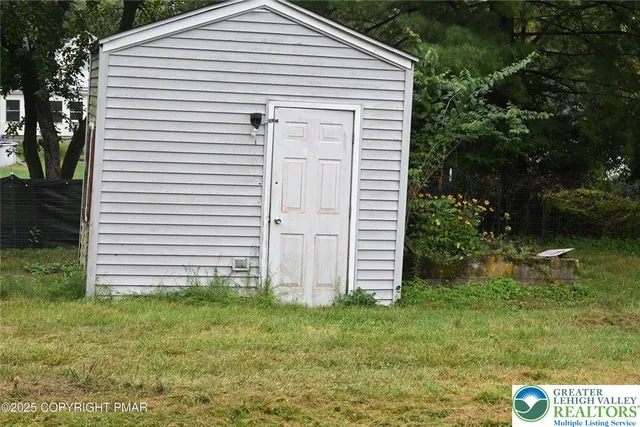 a view of a white house with a yard and plants