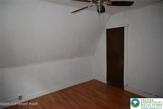 a view of a room with wooden floor and fan