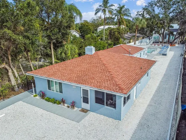 a view of a house with a yard and potted plants