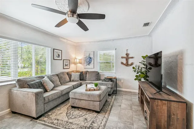a living room with furniture a flat screen tv and a large window