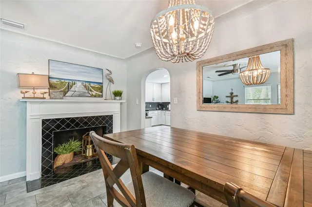 a dining room with wooden floor a chandelier a wooden table and chairs