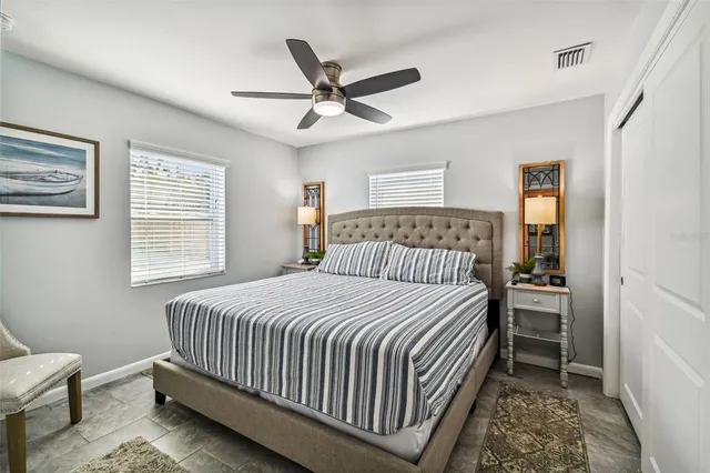 a bedroom with a bed and a ceiling fan