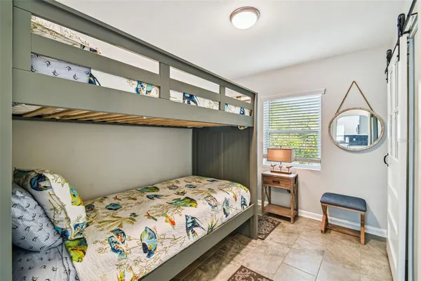 a bedroom with a bed a mirror and a window