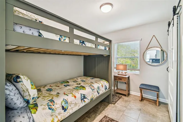 a bedroom with a bed a mirror and a window