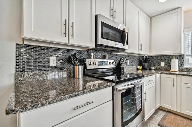 a kitchen with stainless steel appliances granite countertop a sink stove and microwave