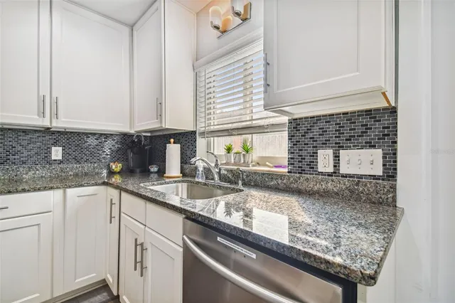 a kitchen with granite countertop a sink and a stove