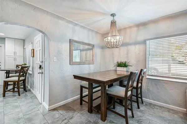 a view of a dining room with furniture a chandelier and wooden floor