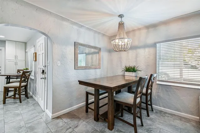 a view of a dining room with furniture a chandelier and wooden floor