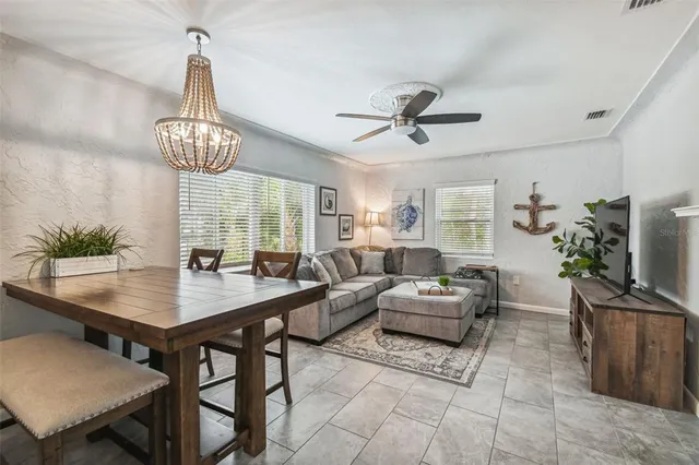 a living room with furniture a chandelier and a flat screen tv