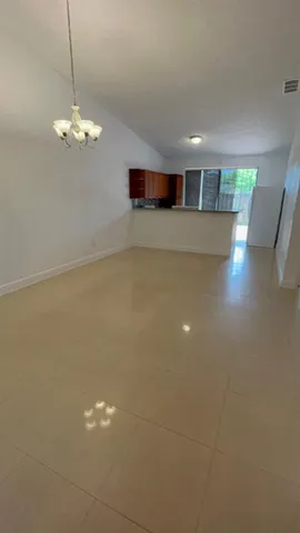 a view of a room with wooden floor and chandelier