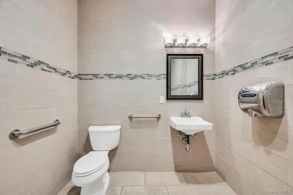 a bathroom with a toilet sink and mirror