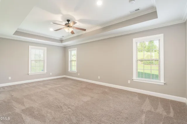 an empty room with windows and fan
