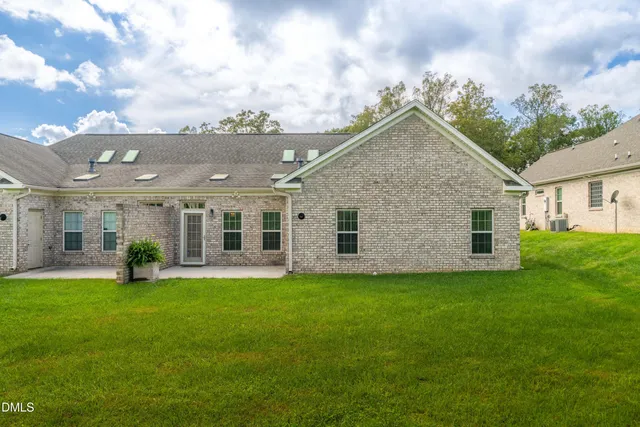 a view of a house with a yard and sitting area