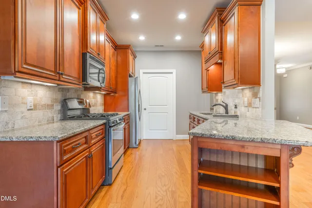 a kitchen with stainless steel appliances granite countertop a sink and cabinets