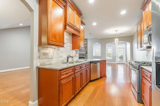a large kitchen with stainless steel appliances granite countertop a stove and a sink