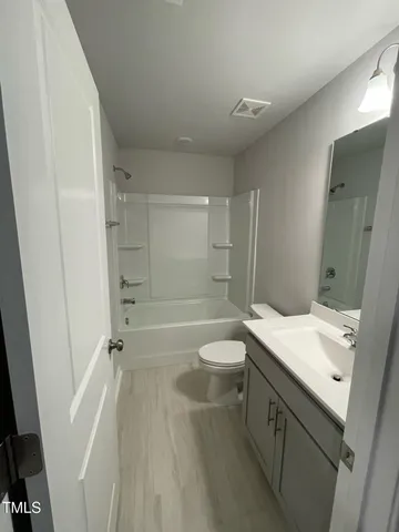 a bathroom with a sink a toilet a mirror and shower
