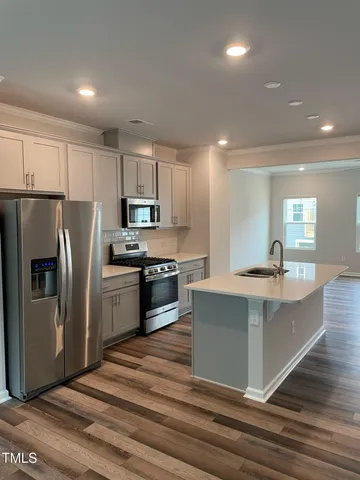 a kitchen with stainless steel appliances a refrigerator sink and microwave