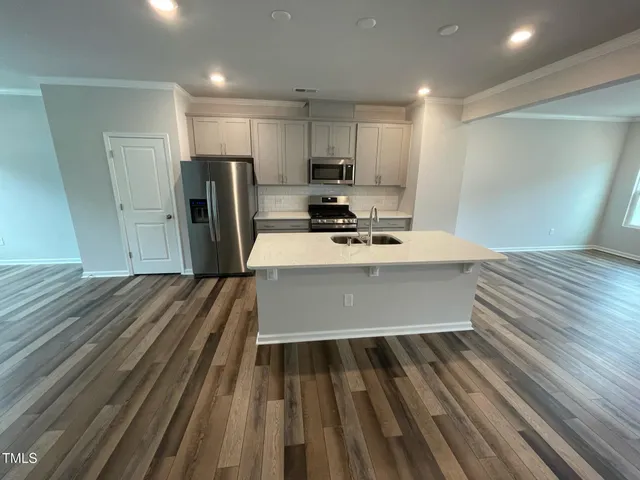 a kitchen with kitchen island a sink appliances and cabinets