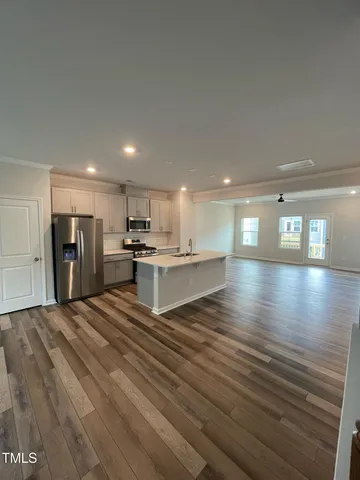 a view of kitchen with refrigerator microwave and wooden floor