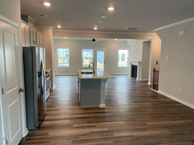an empty room with wooden floor and a view of hallway