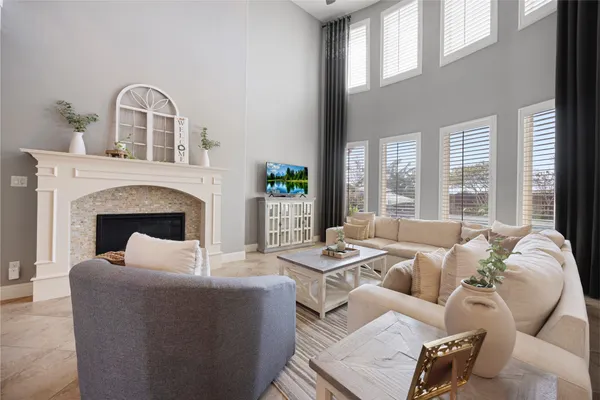 a living room with furniture fireplace and a large window