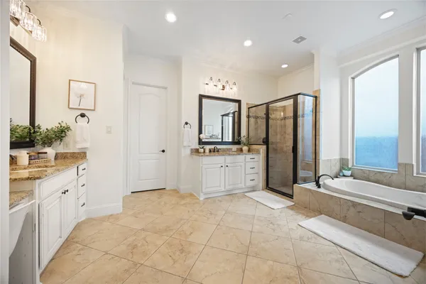 a spacious bathroom with a double vanity sink mirror and bathtub