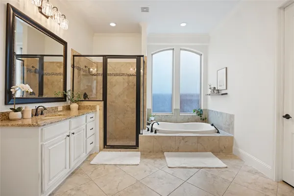 a spacious bathroom with a double vanity sink a mirror and a bathtub