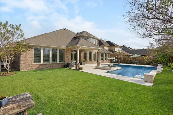 a front view of a house with swimming pool and porch with furniture