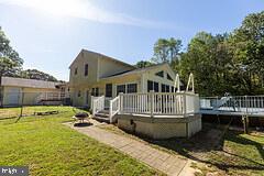 3450 Allday Road Huntingtown, MD 20639 - Photo 4 of 23 a view of a house with a wooden deck and a yard