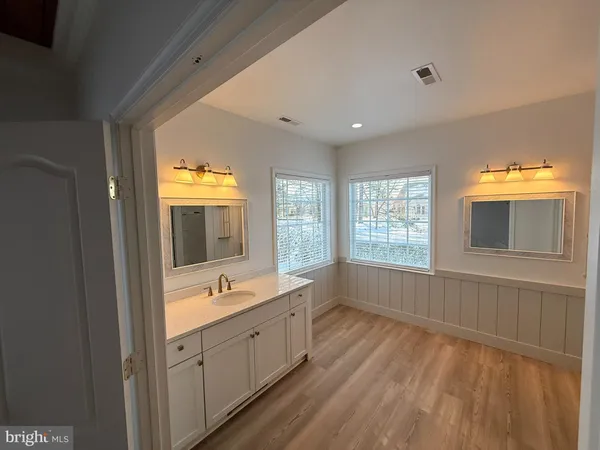 a spacious bathroom with a double vanity sink a mirror and a bathtub