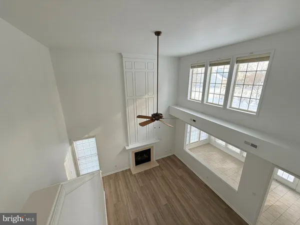 a walk in closet with wooden floor and a window