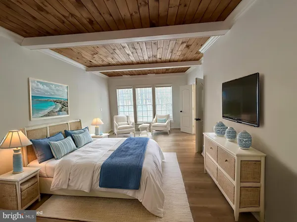 a spacious bedroom with a large bed and a flat screen tv