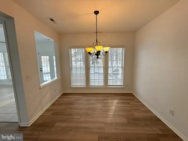 a view of an empty room with window and bathroom